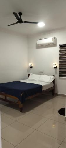 a bed in a white room with a ceiling at Riyanhouse in Pūrnānkuppam