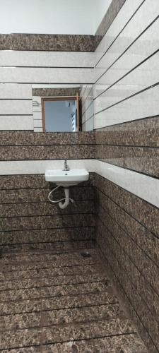 a bathroom with a sink in a brick wall at Riyanhouse in Pūrnānkuppam