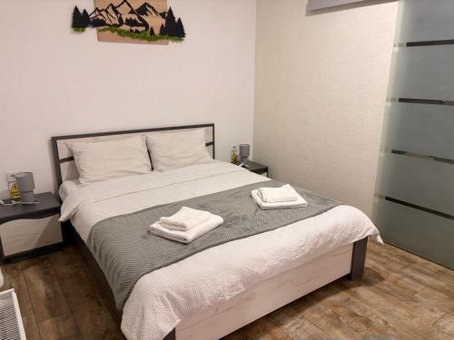 a bedroom with a bed with two towels on it at Casa Orhideea in Borsec