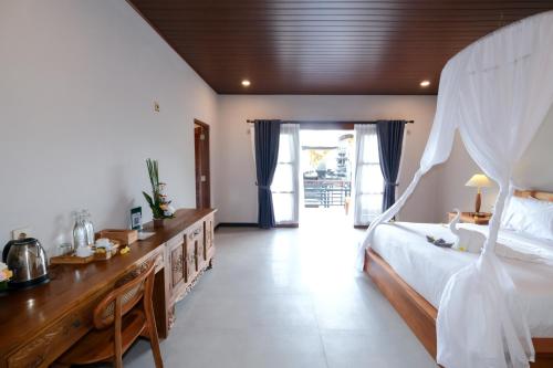 a bedroom with a large bed and a table with a bed sqor at Arsyana Villa in Sidemen