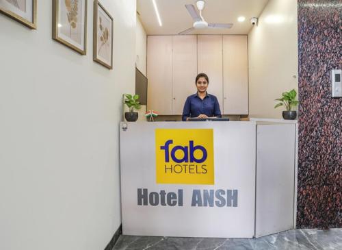 a woman standing behind a reception desk in an office at FabHotel Ansh in Aurangabad