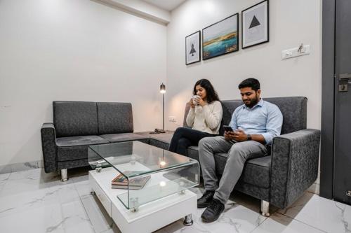 a man and woman sitting on a couch in a living room at FabHotel Ansh in Aurangabad