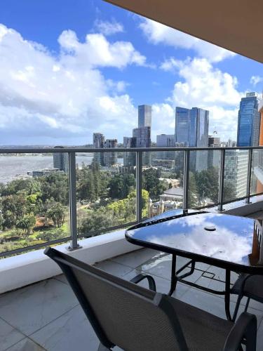 a balcony with a table and chairs and a view of the city at 114 Panoramic River Views 2BR High Floor & Parking in Perth