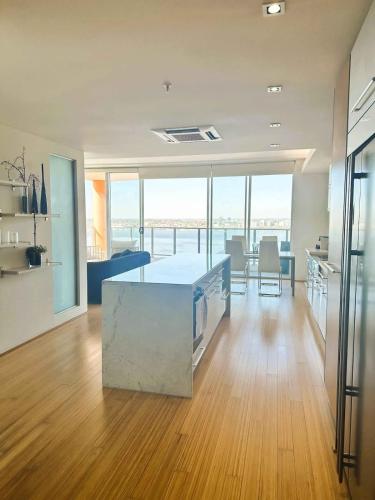 a large kitchen and living room with a table and chairs at 114 Panoramic River Views 2BR High Floor & Parking in Perth