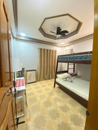 a bedroom with a bunk bed with a ceiling fan at Naybe's Room rentals in Dapa