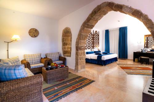 a bedroom with a bed and a living room at The Old Village Hotel & Resort in Wadi Musa