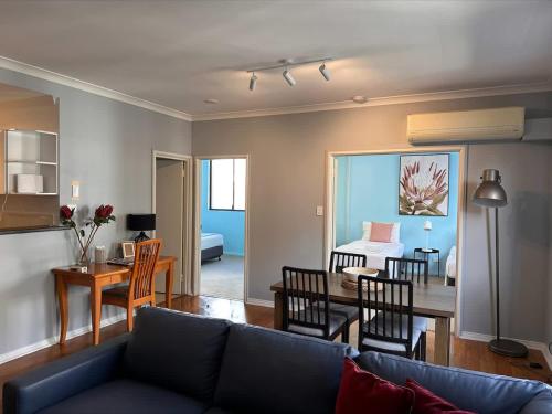 a living room with a couch and a dining room at 73 Serene 2BR Apt Perth CBD Pool-Gym & FREE Parkng in Perth