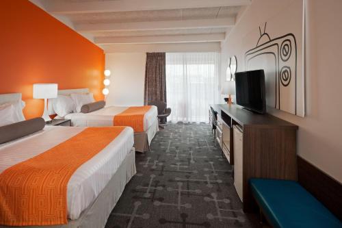 ein Hotelzimmer mit zwei Betten und einem Flachbildfernseher in der Unterkunft Howard Johnson by Wyndham Toms River in Toms River