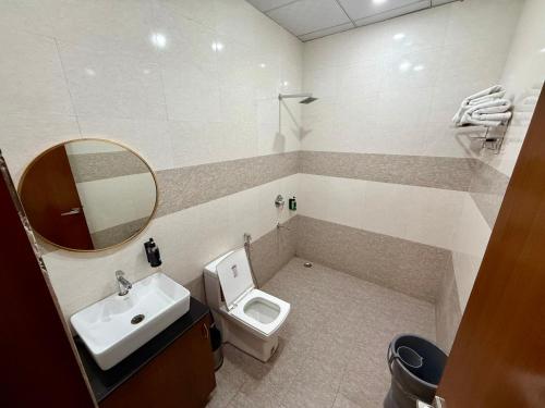 a bathroom with a sink and a toilet and a mirror at New Crown Plaza in Jodhpur