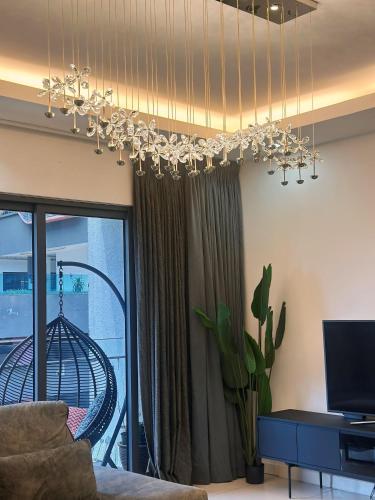a living room with a chandelier and a balcony at 3BR family friendly Apartment at The Elements Ampang Kuala Lumpur in Kuala Lumpur
