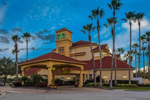 a hotel with a clock tower on top of a building at La Quinta by Wyndham Orlando Airport - On Property Food Trucks & Free Airport Shuttle! in Orlando