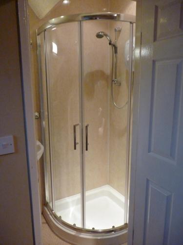 a shower with a glass door in a bathroom at Autumn Leaves Guest House in Windermere