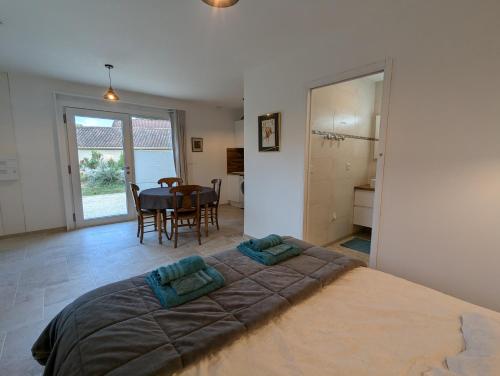 a bedroom with a large bed and a dining room at domaine de marodi jasmin in Baignes-Sainte-Radegonde