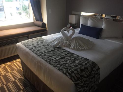 a hotel room with a bed with a heart decoration on it at Microtel Inn & Suites by Wyndham Ocean City in Ocean City