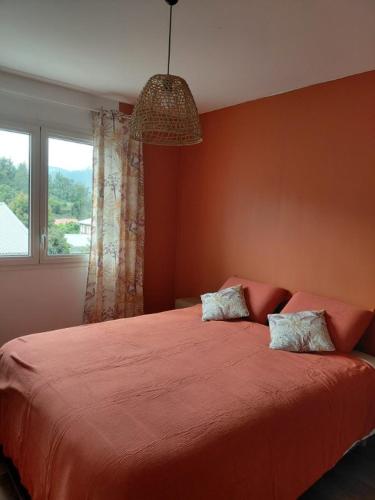 a bedroom with a large red bed with a window at Ti Kaz Salazie 2 in Salazie