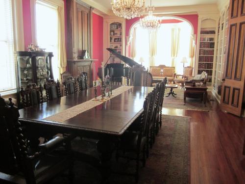 ein Esszimmer mit einem langen Tisch und Stühlen in der Unterkunft Baer House Inn in Vicksburg