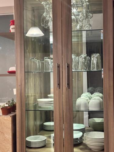 a glass cabinet with plates and dishes in it at Kennedy Guest House in Cusco