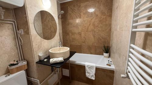 a bathroom with a tub and a sink and a mirror at Tudor's apartment in Bucharest