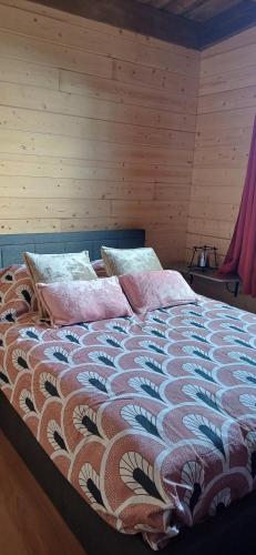 a bed with pillows on it in a room at Les chalets de la mare in Entre-Deux
