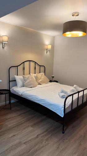 a bed with white sheets and pillows in a room at Tudor's apartment in Bucharest