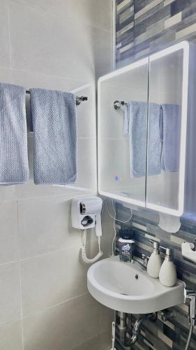 a bathroom with a sink and a mirror and towels at Casa Solara in General Santos