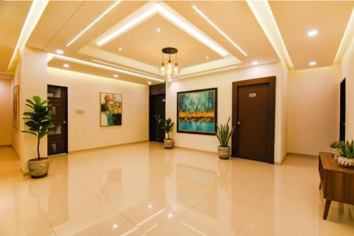 a large lobby with a coffered ceiling and potted plants at FabHotel Golden Heights in Hinjewadi