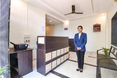 a man in a blue suit standing in a room at FabHotel Golden Heights in Hinjewadi