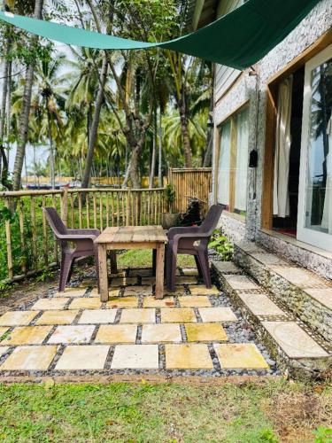 a picnic table and two chairs on a patio at Villa Lakdu in Sorongjukung