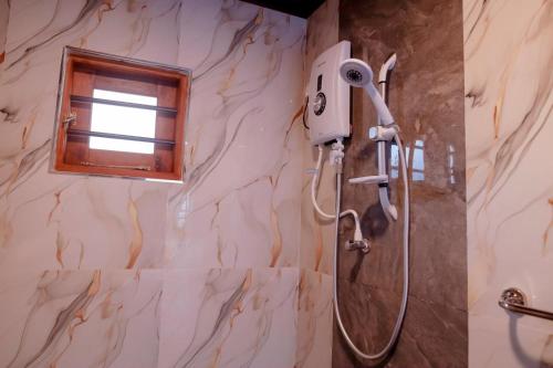 a shower in a bathroom with a window at Arunella Beach Villa in Tangalle