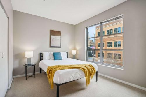 a bedroom with a bed and a large window at CozySuites 2BR Mill District with pool, gym #04 in Minneapolis