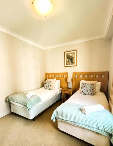 two beds sitting in a room with at 10 CBD Resort 2BR Secure Suite Pool Gym & Parking in Perth