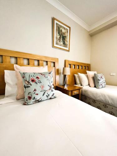 a bedroom with two beds and a pillow on the bed at 10 CBD Resort 2BR Secure Suite Pool Gym & Parking in Perth