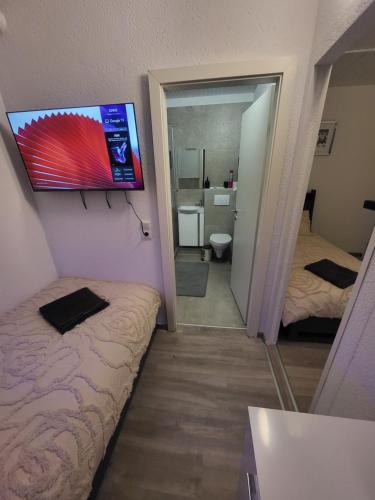 a room with two beds and a television on the wall at Pension Mediterrano - Monteurzimmer in Bedburg