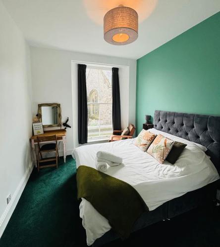 a bedroom with a large bed and a window at 2 Historic Tenby Tourist Favourite -Steps to Beach in Pembrokeshire