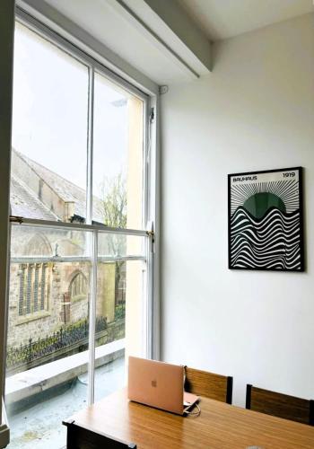 an office with a laptop computer on a desk next to a window at 2 Historic Tenby Tourist Favourite -Steps to Beach in Pembrokeshire