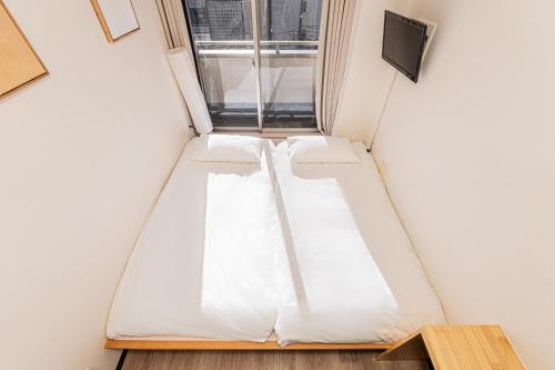 a room with a bed and a window at Louis stage showamachi in Tokyo