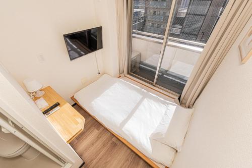 a small room with a bed and a window at Louis stage showamachi in Tokyo