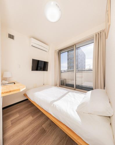 a bedroom with a large bed and a window at Louis stage showamachi in Tokyo