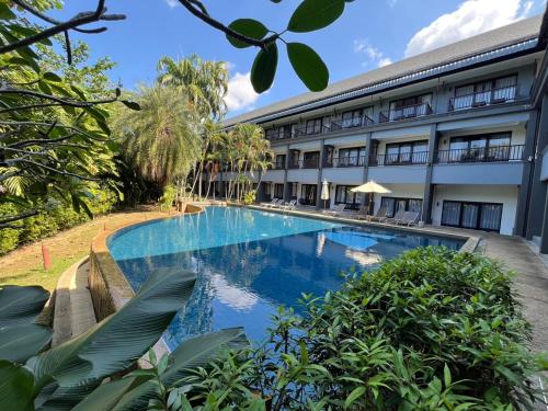 an external view of a hotel with a swimming pool at Khao Lak - Loft Suite with 2 king size beds, bathroom with bathtub in Khao Lak