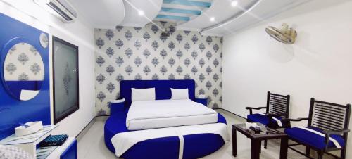 a blue and white bedroom with a bed and a desk at Hotel Grace Inn Multan in Multan