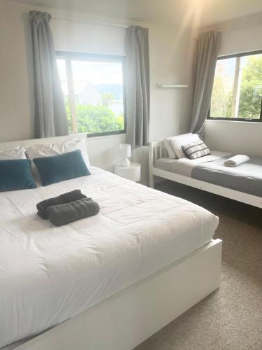 a bedroom with a large white bed and a couch at Lakeside Retreat 3BR 2Bath Epic Views in Queenstown