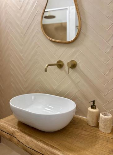 a bathroom with a white sink and a mirror at Baia Dorata beach apartments in Porto Istana