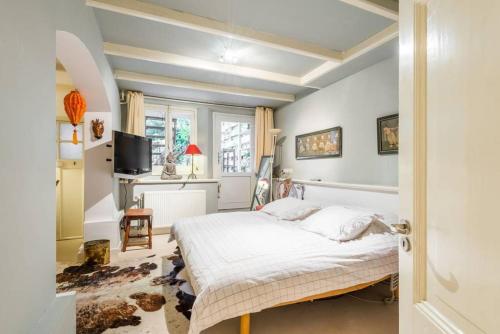 een slaapkamer met een bed en een tv. bij Perfect APT - Heart of Amsterdam in Amsterdam