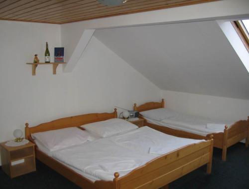 een slaapkamer met 2 bedden op een zolder bij Wellness Pension Iveta in Žacléř
