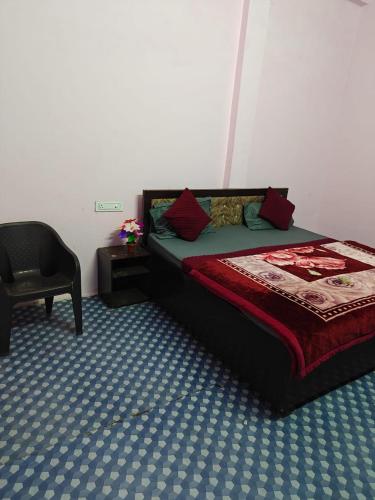 a bedroom with a bed and a chair in it at Shri Prabhu guest house in Ayodhya