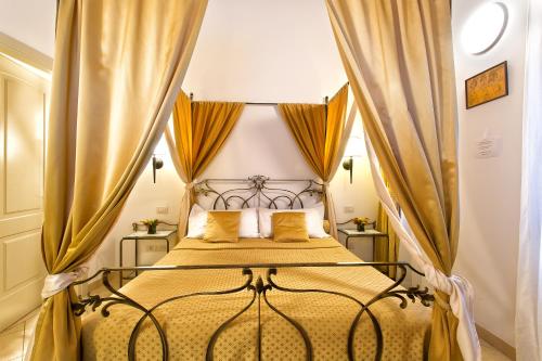 sypialnia z łóżkiem z baldachimem i zasłonami w obiekcie Alla Vite Dorata w Wenecji