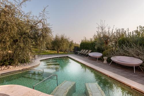 una piscina con 2 sillas junto a en Villasanpaolo Resort & Spa en San Gimignano