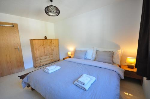 a bedroom with a blue bed with two towels on it at Family Frame Apartment in Lauterbrunnen