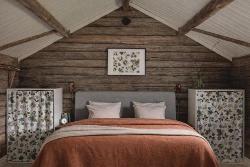 a bedroom with a bed in a wooden room at Smålandstorpets lanthotell in Hok