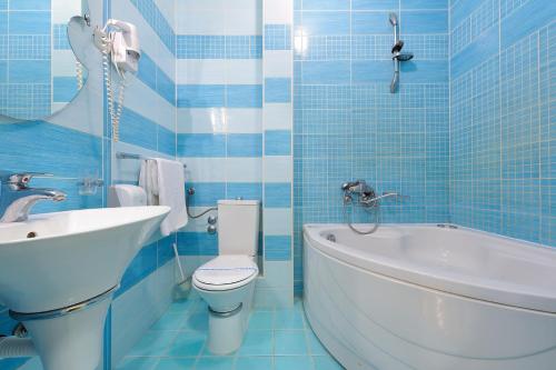 a bathroom with a toilet and a tub and a sink at Hotel Dragović Smederevo in Smederevo
